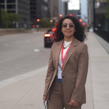 A professional photograph of a woman standing on a city street.